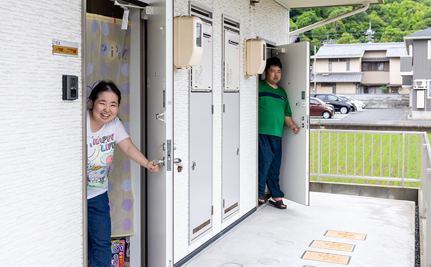 グループホームの玄関前で、入居者がそれぞれ自室のドアから顔を出している